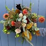 Autumn style bouquet in orange, brown and green tones.