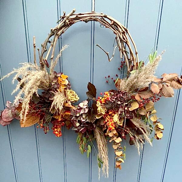 Vine wreath with autumn colours and flowers on