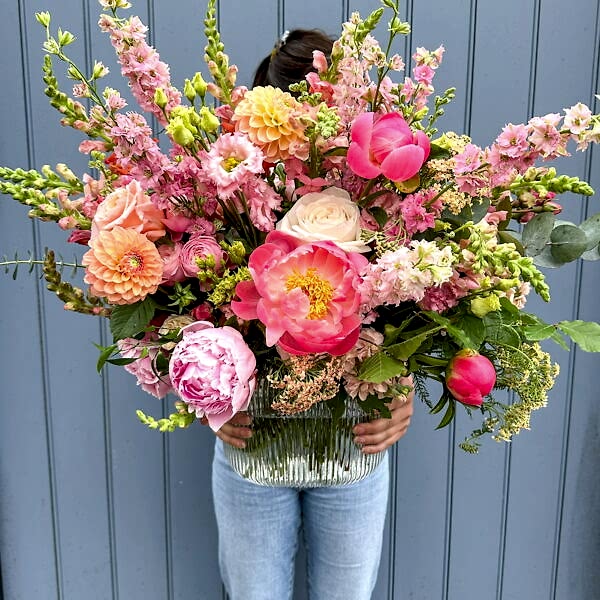 Peach, pink and coral vase display filled with seasonal blooms